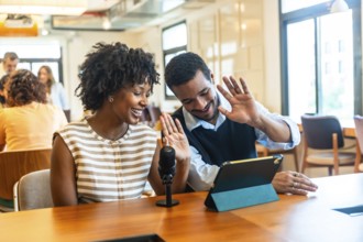 Diverse colleagues creating digital content together, streaming a live video podcast from their