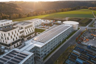 Industrial complex with solar systems next to green fields in the evening light, new hospital, Calw