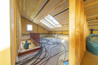 Top floor during renovation with cable harnesses and skylights that illuminate the room