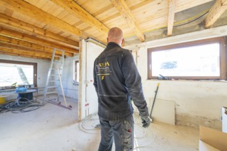 Person working in an attic lit with daylight during renovation