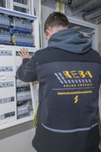 Electrician working on a control cabinet with complex cabling