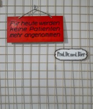 Information signs on a small metal grid in front of a doctor's office, Berlin, Germany
