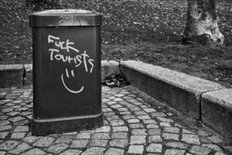 Trash cans, trash cans, graffiti FUCK TOURISTS, protest against tourists, black and white, Free and