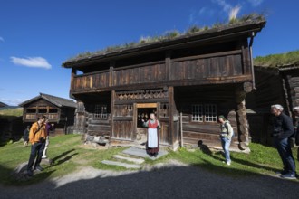 Tourist guide in traditional traditional costume and visitor, Bjørnstad, farm from Vågå, Maihaugen