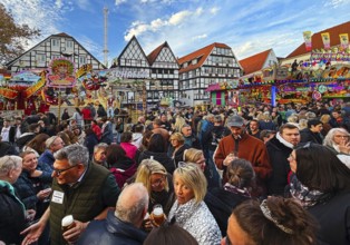 Many people at the All Saints Fair in front of half-timbered houses, largest old town fair in