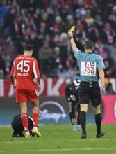 Referee Sven Jablonski showing Aleksandar Pavlovic FC Bayern Munich FCB (45) yellow card yellow