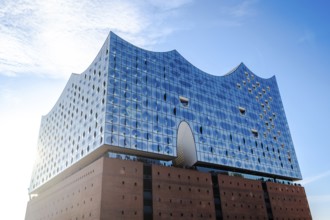 The modern Elbe Philharmonic Hall with its unique glass façade rises majestically against the blue