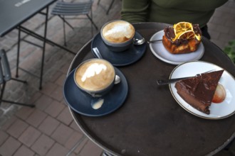 Cappuccino and cake served on a tray in a street café, Hanseatic City of Lübeck,