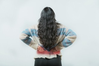 Suffering young woman with pain holding his back isolated. Female with spine problems isolated.