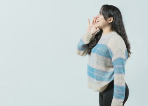 Young asian woman shouting an announcement. Beautiful asian girl shouting a promotion isolated