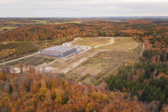 Industrial plant surrounded by autumnal forest with fields and roads in the background, new