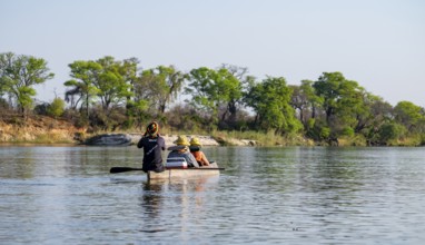 Boat trip, tourists in a Mokoro, dugout boat on the Okavango River, Caprivi Strip, Namibia