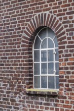 Old brick wall with an arched window and a rustic architectural style, Düstermühle, Münsterland,