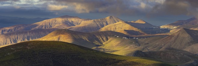 La Geria wine region, behind the volcanic formation Los Ajaches at sunrise, Lanzarote, Canary