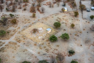 Settlement, simple house and fence, dry savanna landscape, near Maun, aerial view, Okavango Delta,