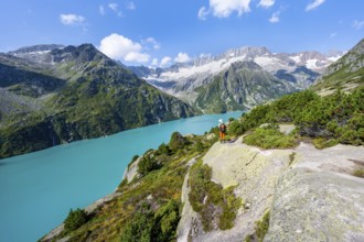 Mountaineers in front of picturesque mountain landscape, turquoise-blue mountain lake