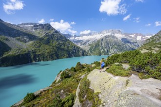 Female mountaineer in front of picturesque mountain landscape, turquoise-blue mountain lake