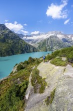 Female mountaineer in front of picturesque mountain landscape, turquoise-blue mountain lake