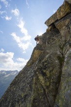 Female mountaineer on steep rock face on the secured via ferrata Krokodil-Bergsee am