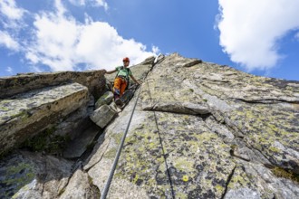 Mountaineers on steep rock face in the secured via ferrata Crocodile Mountain Lake at