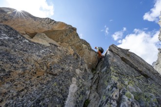 Mountaineers on steep rock face in the secured via ferrata Crocodile Mountain Lake at