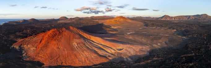 Picturesque volcanic landscape in evening light, red volcano Montaña Bermeja between lava fields,