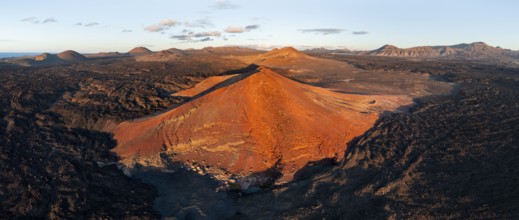 Volcanic landscape in evening light, red volcano Montaña Bermeja between lava fields, aerial view,