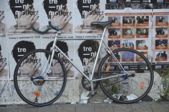Racing bike set against a wall filled with posters in Odense, Fyn, Funen island, Denmark,