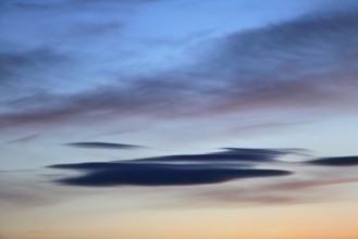 Colourful clouds spread over a blue-orange sunset sky and appear peaceful, Peenetal nature park