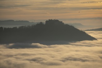 Airplane at sunset over a sea of fog from Beurener Fels to Hohenneuffen Castle, Swabian Alb,