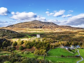 Autumn colours over Castell Dolwyddelan and Eryri Mountains from a drone, Snowdonia, Conwy County