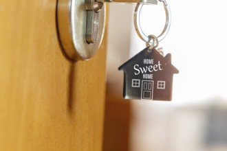 Close-up of a key ring with the inscription HOME SWEET HOME (symbolic image, digitally reworked)