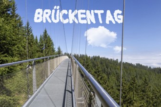 Bridge Day Symbolic image: Suspension bridge with font BRÜCKENTAG inserted in the sky (digitally