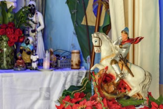 Image of Saint George on his horse with an Umbanda altar in the background