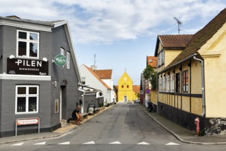 Street with bar and half-timbered houses, yellow church in Allinge, Treppengable, Allinge-Sandvig,