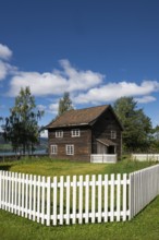 Old farmhouse surrounded by a white-painted fence, Maihaugen open-air museum with houses and