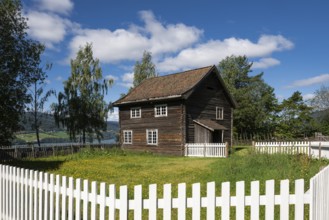 Old farmhouse surrounded by a white-painted fence, Maihaugen open-air museum with houses and
