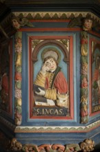 Wooden relief of Evangelist Luke on pulpit decorated with angels and fruits by Peder Knudsen
