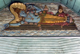 Painted wooden relief, Hindu god Vishnu on the snake Shesha in the primeval sea with wife Lakshmi