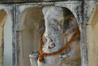 A Ganesha statue decorated with flower garland, Devigarh Palace Hotel, Delwara village near