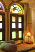 Interior with colorful window, cozy seating area with pillows and lamp, Karni Fort Bambora Palace