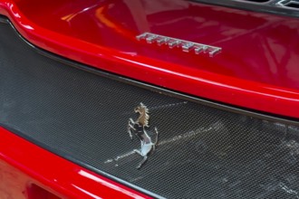 Close-up cutout detail part of red rear rear end of sports car Supercar Ferrari with logo trademark