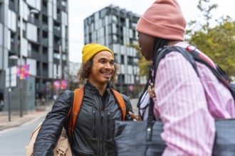 Young diverse friends smiling and chatting on a city street, casually dressed in street style,