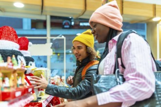 Young diverse couple shopping for holiday decorations, selecting gifts and enjoying their time