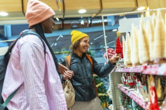 Young Mixed-race couple happily shopping for festive holiday decorations, selecting small christmas