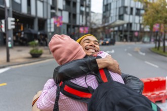 Enthusiastic young men sharing a warm embrace and smiling sincerely during a happy reunion on an