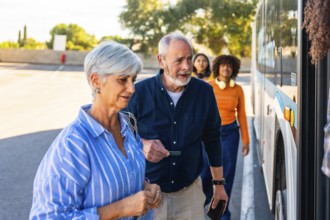 Senior couple approaching a bus entrance, showing a man holding a ticket while waiting in line with