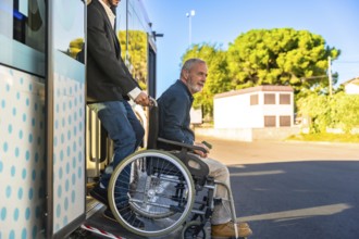 Caregiver assisting a smiling senior man using a wheelchair onto a public bus via an extendable