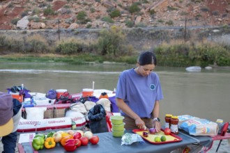 Loma, Colorado - A river guide prepares a meal during a rafting trip through the Colorado River's
