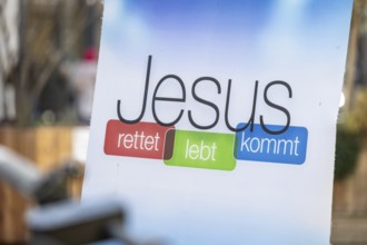 Sign with the inscription JESUS RETTET LEBT KOMMT at the information stand of a free church in